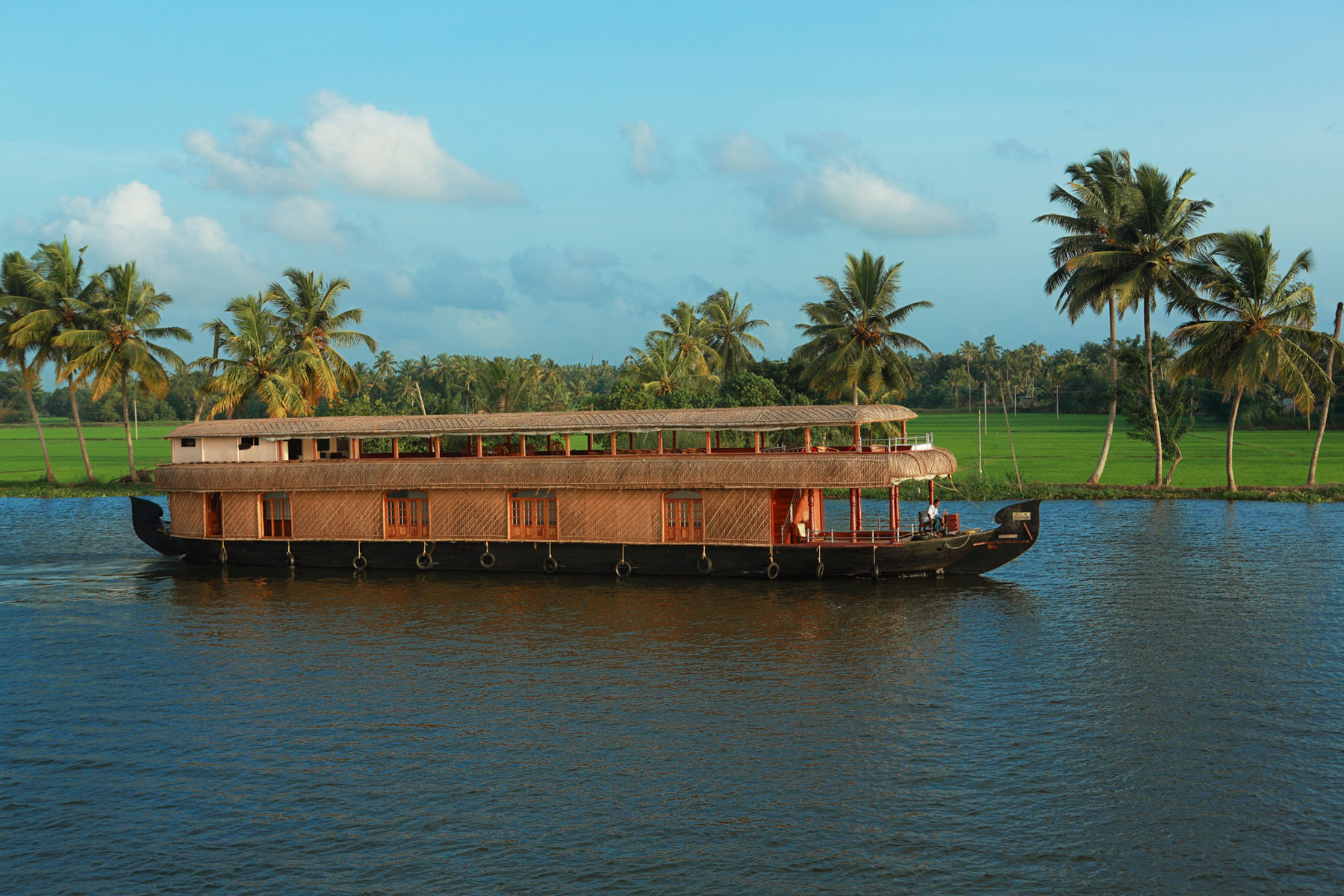 Traditional thatched luxury houseboat cruising through peaceful Alleppey backwaters